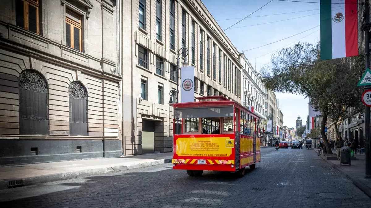 Vue de la façade de l'hôtel Bellas Artes avec un bus touristique dans la rue.
