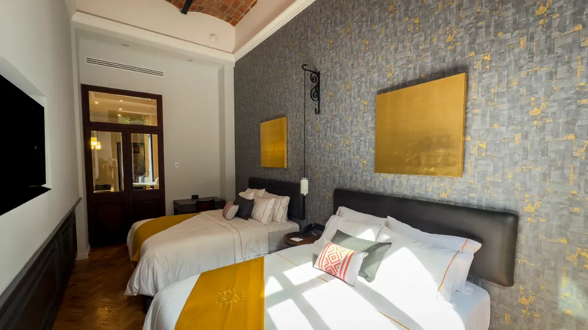 Queen Suite with two beds at Hotel Bellas Artes. A luxurious space with a spacious hallway and TV.